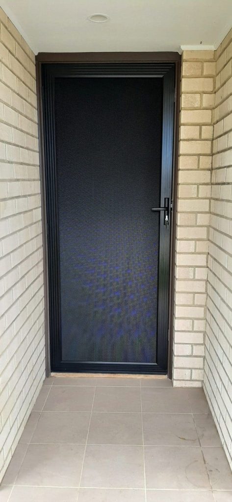 A black door with a window set in a brick wall, showcasing security screen doors adelaide by Knight Shutters and Improvements.