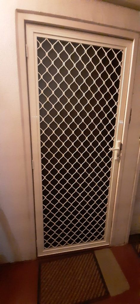 A door protected by a metal grate, representing the security screen doors adelaide offered by Knight Shutters and Improvements.